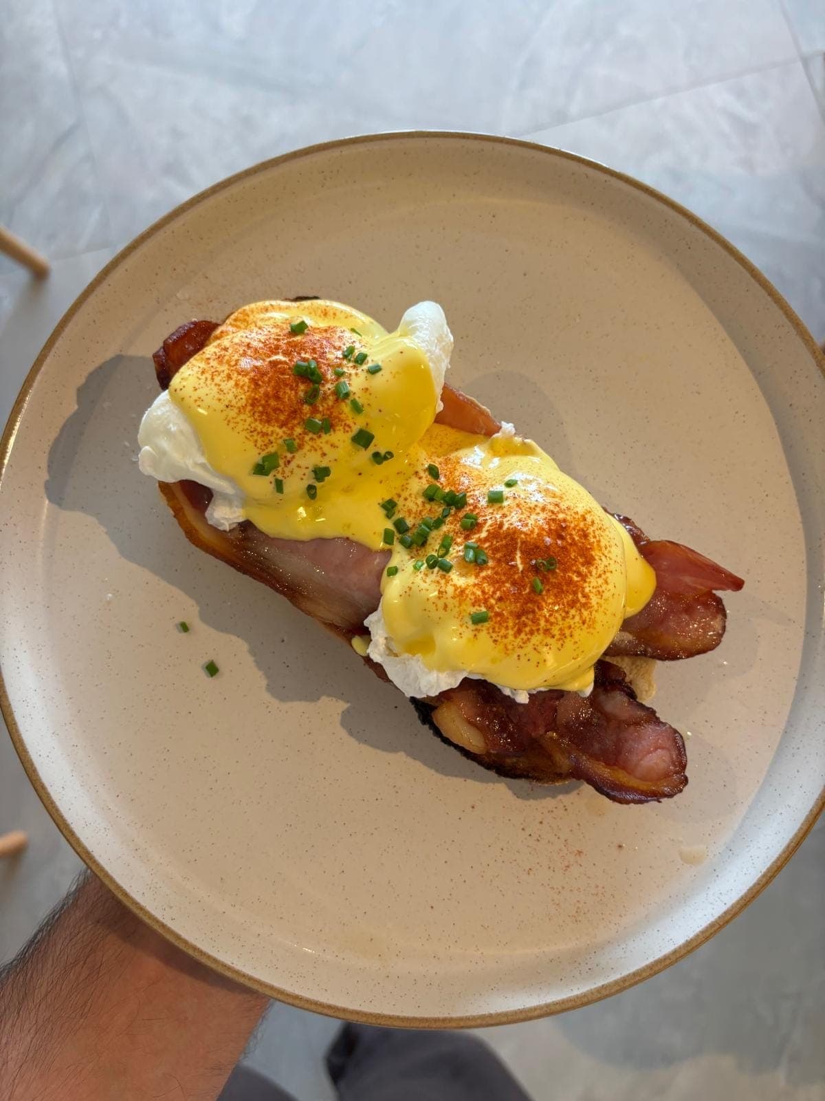 Eggs Benedict with poached eggs, crispy dry cured bacon, house hollandaise and chopped chives