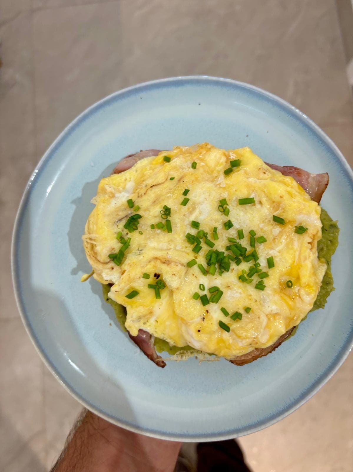 Soft scrambled omelette served over crushed avocado and smoked bacon on artisan sourdough, topped with chives